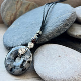Larvakite donut pendant wrapped with sterling silver swizzel on adjustable black cord