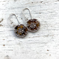 round tigers eye drop earrings, set behind silver spiral setting, hanging on silver hook earrings.