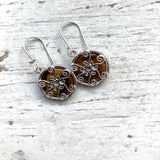 round tigers eye drop earrings, set behind silver spiral setting, hanging on silver hook earrings.